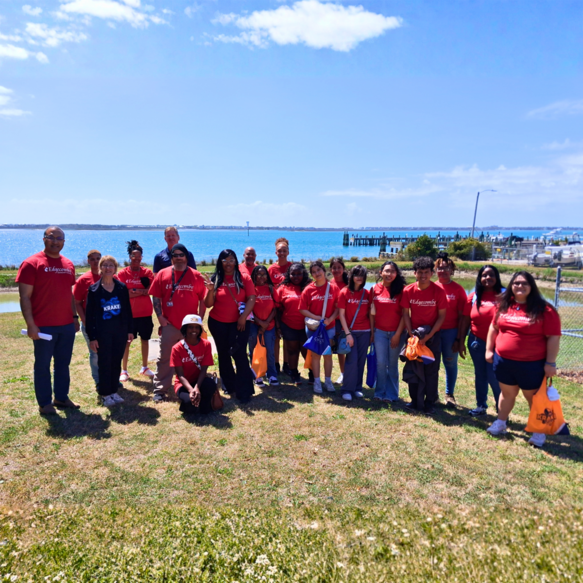 Large group of students standing in front of body of water