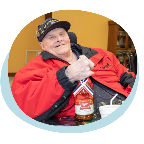 An older white veteran in a wheelchair smiling.