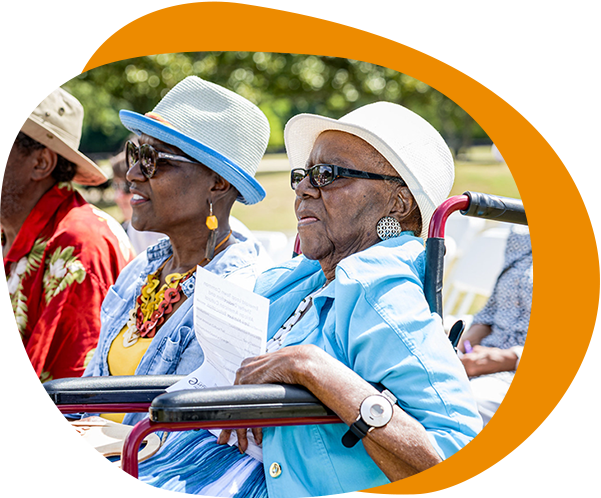 Two older women sitting at outdoor event