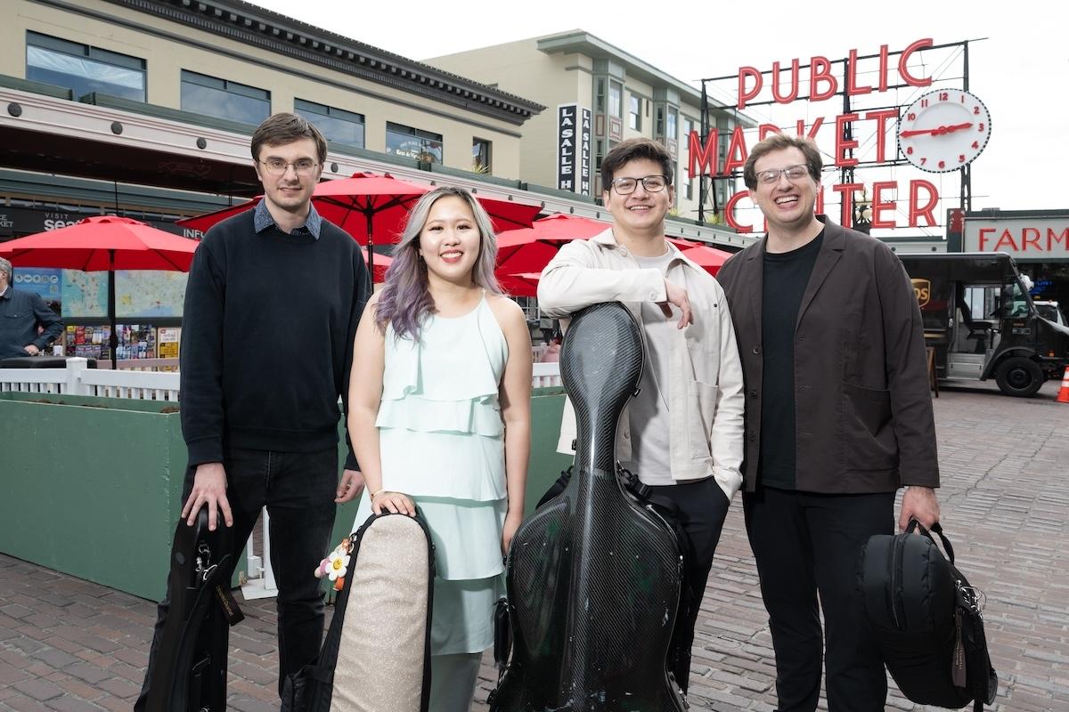 Four people with musical instruments stand in Downtown Seattle
