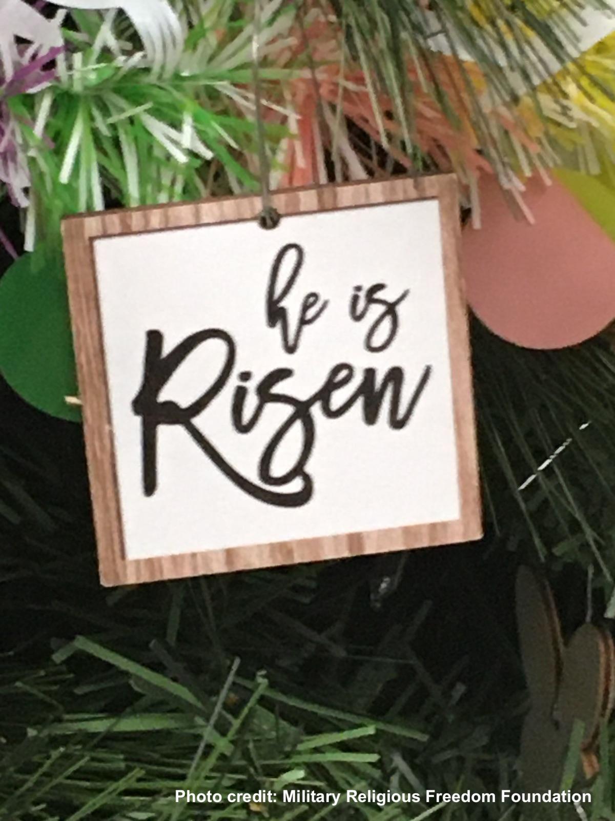 Close up of he is risen sign on Easter tree