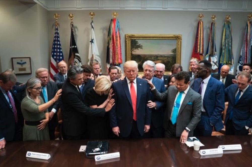 Large group of fundamentalist evangelicals led by Paula White laying their hands on Donald Trump in the White House