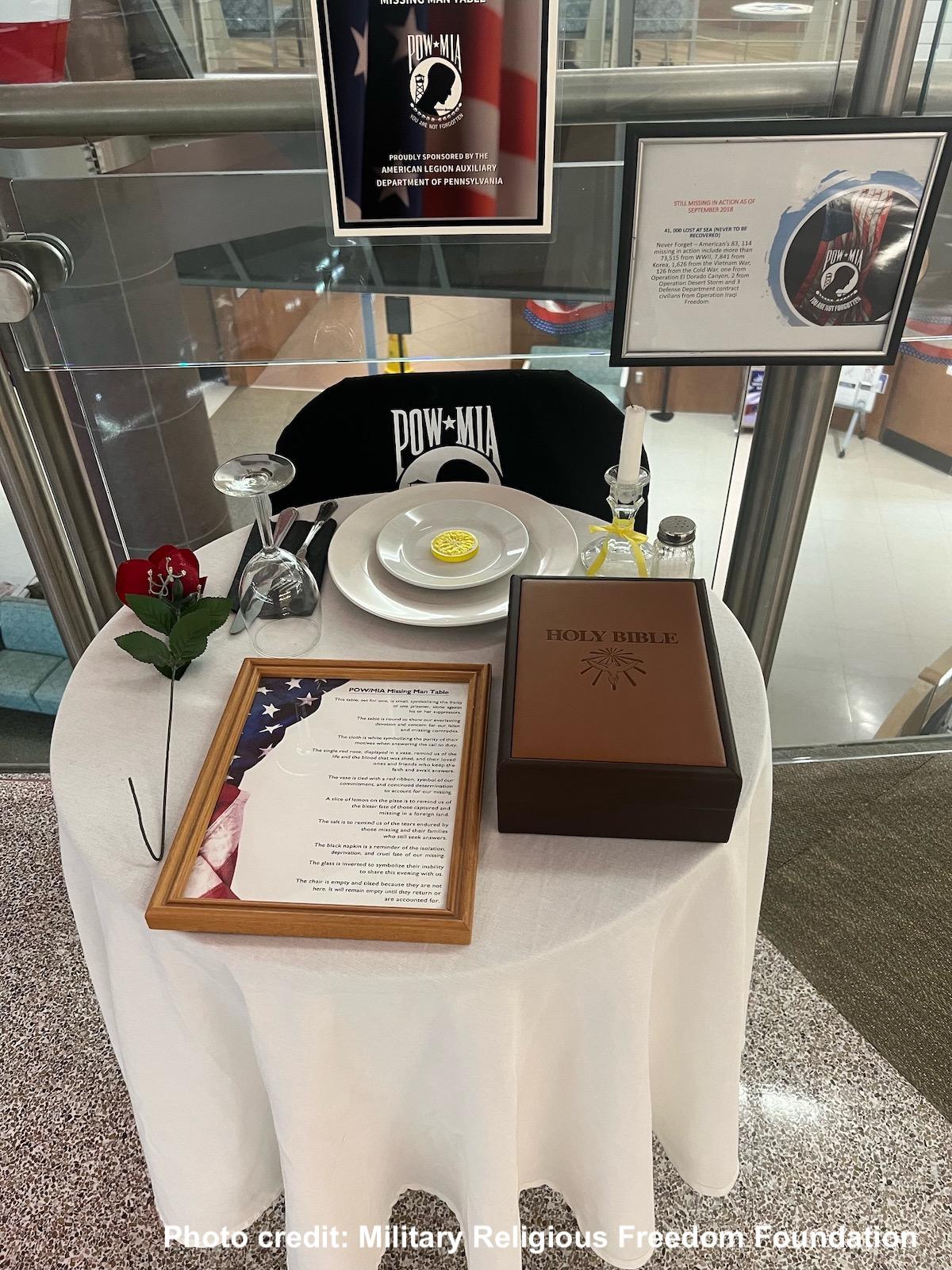 Photo of table now showing that the Bible currently on it is enormous. Bigger than the size of the dinner plate and covering about a third of the width of the table.
