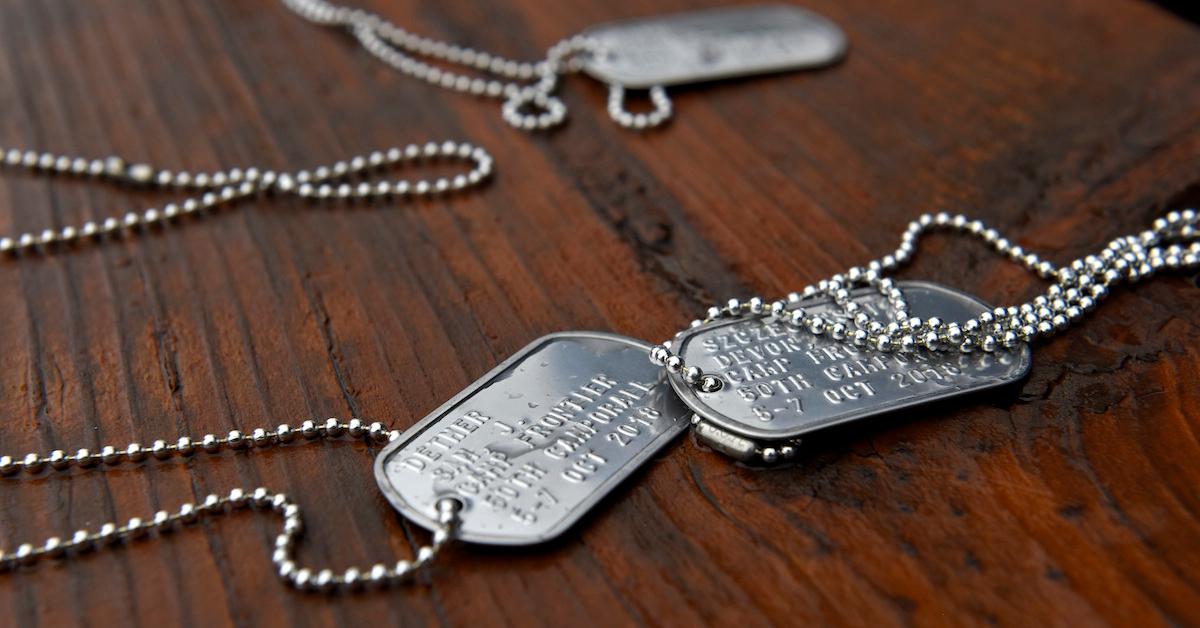 Several sets of dog tags lying on wood background