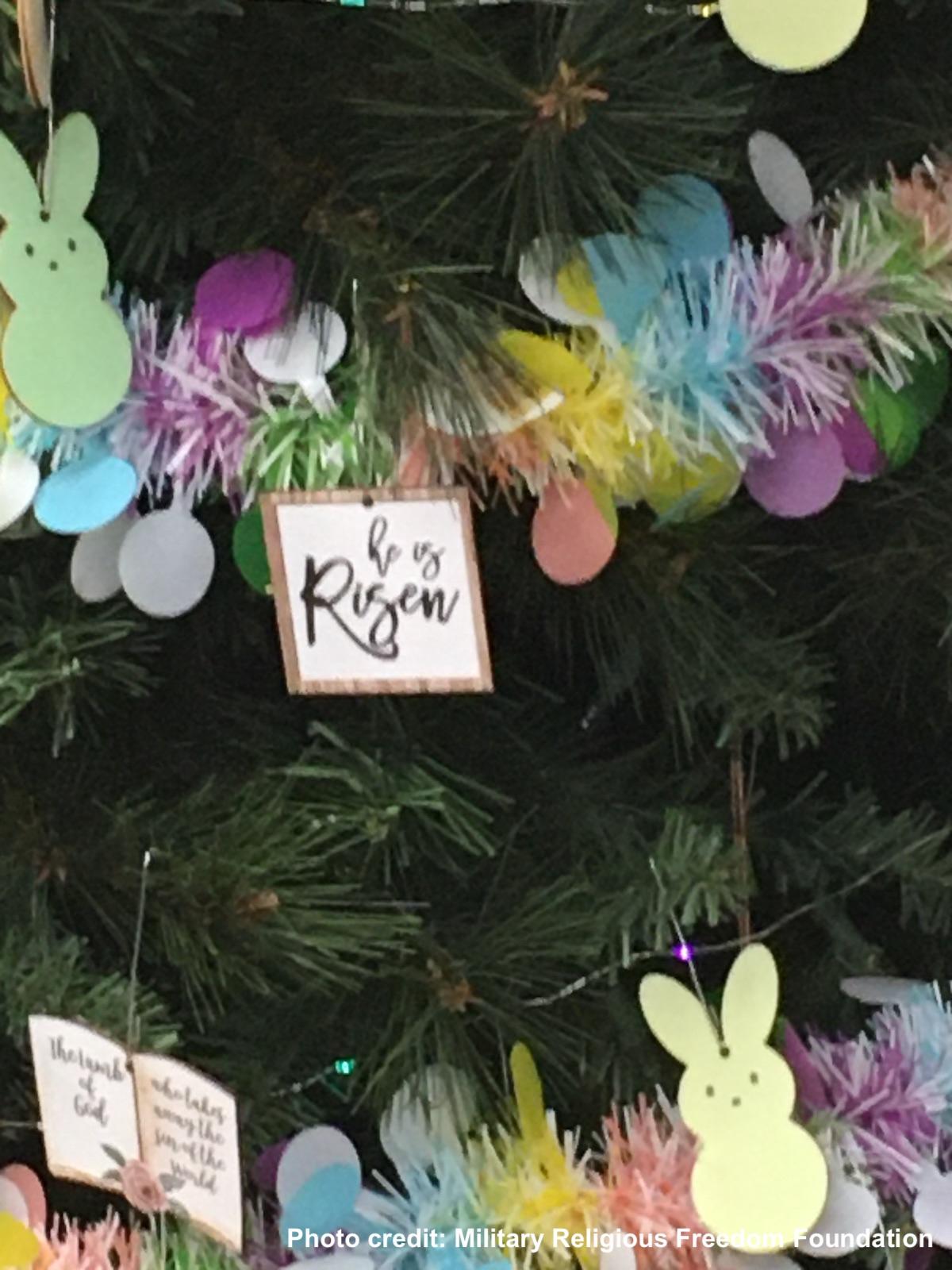 Close up of he is risen ornament on easter tree