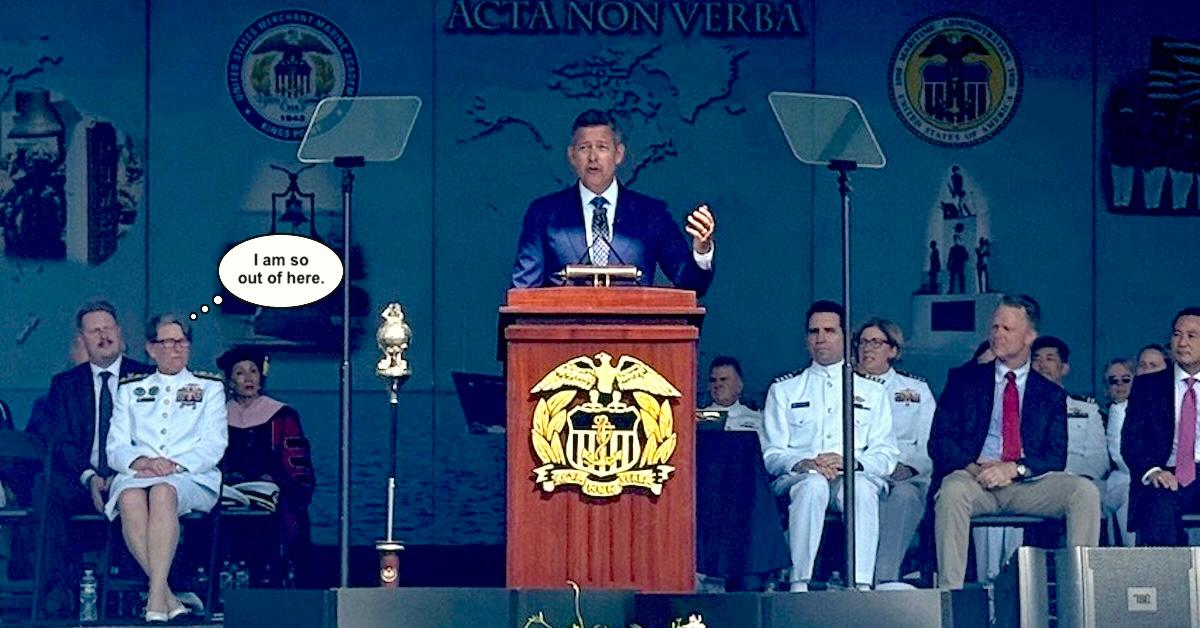 Sean Duffy at podium delivering Marchant Marine Academy commencement address with Vice Admiral Nunan seated behind him with thought ballon above her head saying I am so out of here