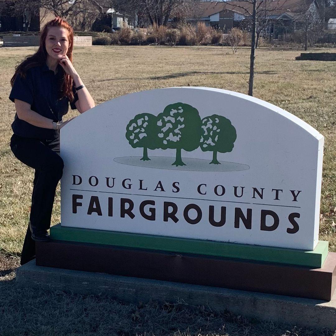 Charlie Cooper standing next to the Douglas County Fairgrounds sign
