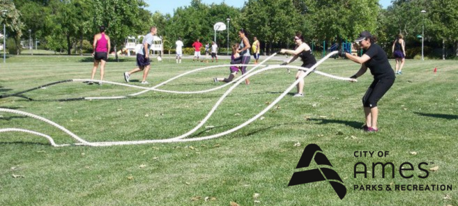 Adults working out with battle ropes in the park