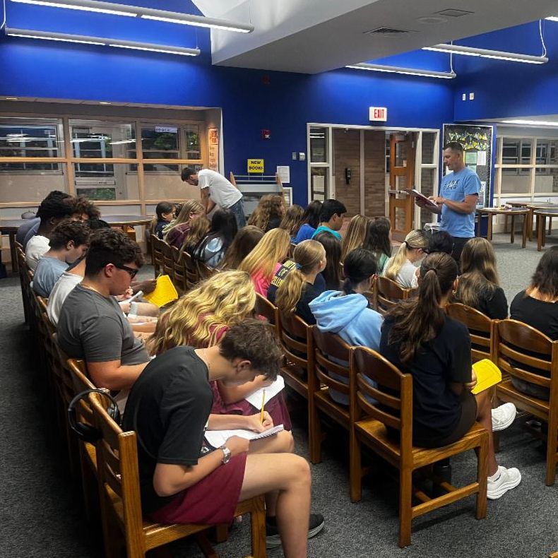 high school students in library with teacher