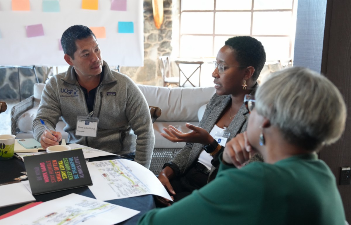 A man and two women seated at a table in conversation