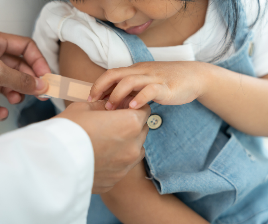 Dr applying bandage to child's arm