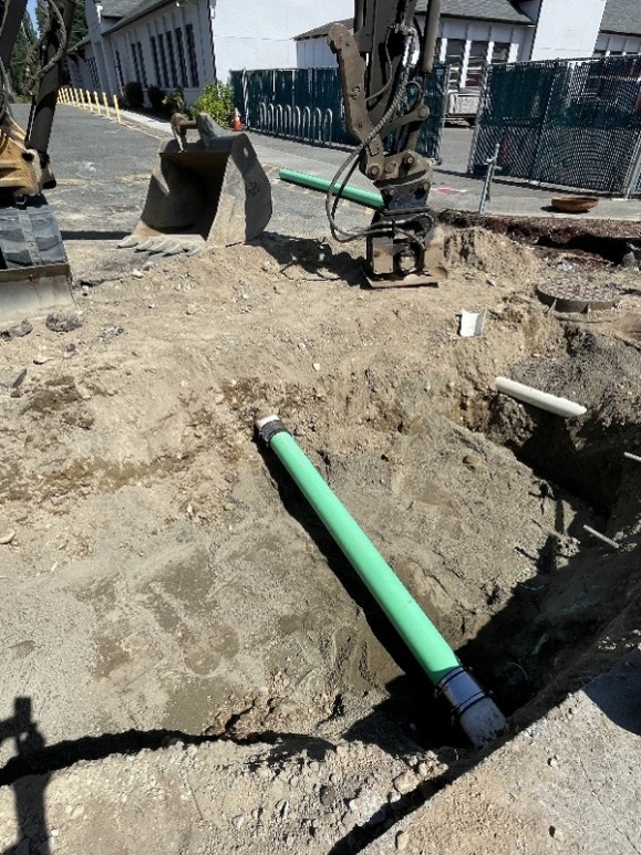 New sewer replacement pipe at the bottom of a big dirt hole.