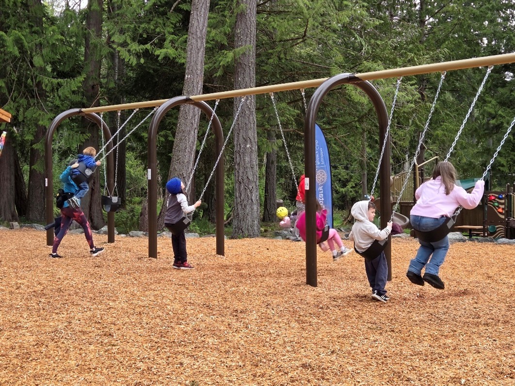 Children enjoying the day and swinging on the new swing set at Rotary Morrow Park.