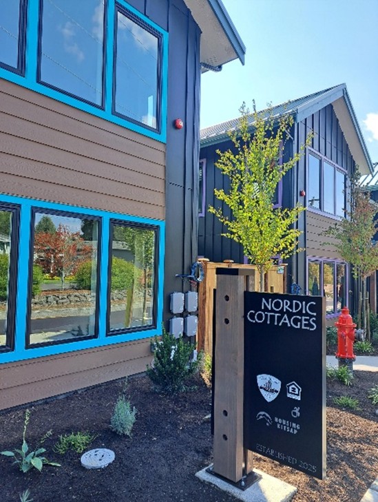 Nordic Cottages sign in front of the brown with blue trim cottage.