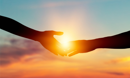 Giving a helping hand on the background of the dawn