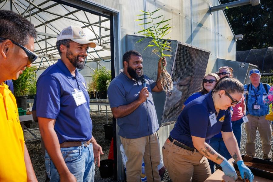 Trequan McGee - assistant professor and horticulture Extension specialist - holds a ginger plant while speaking at Ginger Production Field Day at the North Carolina Agricultural and Technical State University Farm.