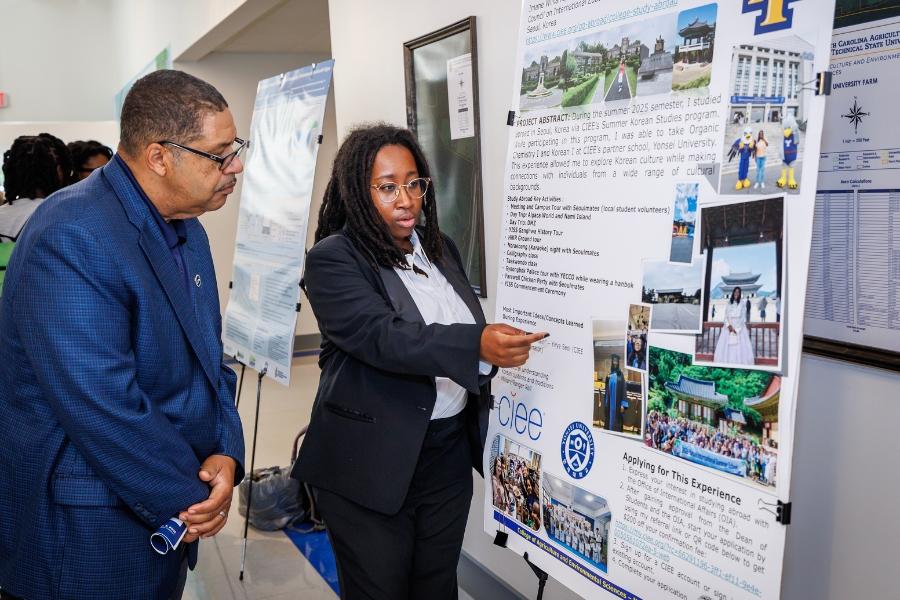 Dr. Goins views the poster display by Imane Williams detailing her study abroad experience in South Korea