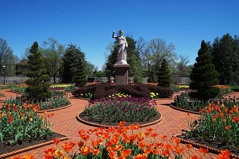 Courtyard at the Missouri Botanical Garden in St. Louis with statue and colorful flowers 