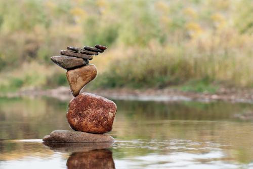 Pile of rocks balanced precariously above the waterline of a body of water