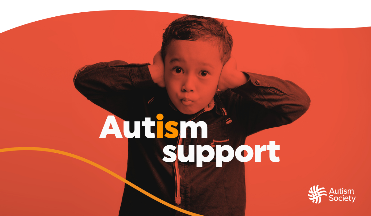 A young boy covering his ears