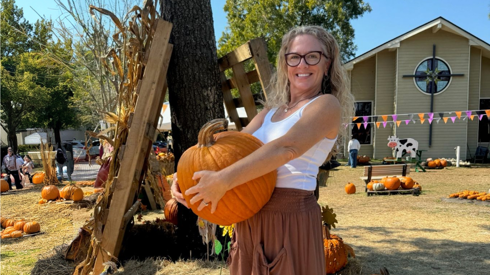 Shanon holding a pumpkin at a previous Pumpkin Patch event