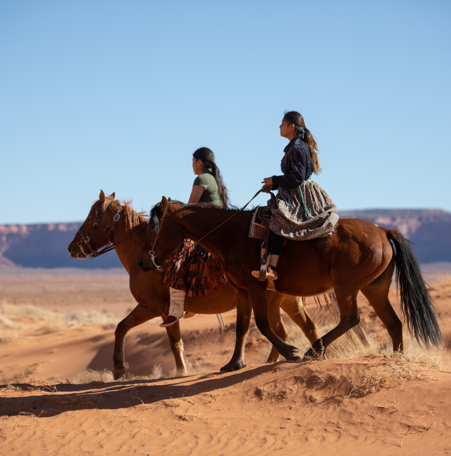 Native American sisters riding horses in Monument Valley, Arizona