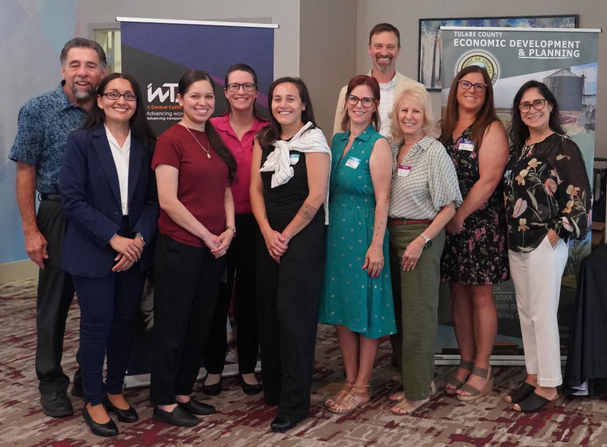 Claudia Sanchez, Alida Verduzco Silva, Reed Schenke, Michael Washam, and members of the Women in Transportation Seminar Central California Chapter pose for a group photo following the South Valley Membership Luncheon.