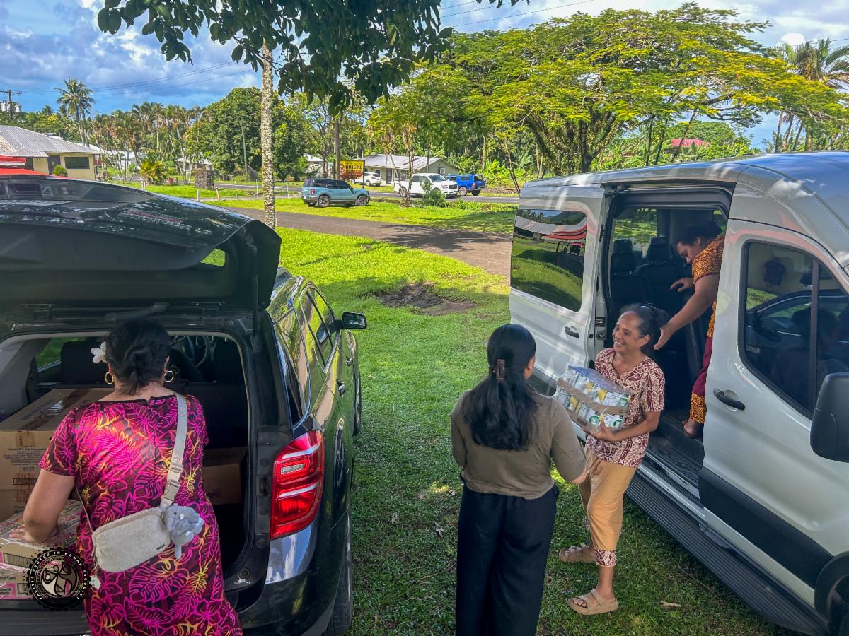 Students loading canned food boxes into van.