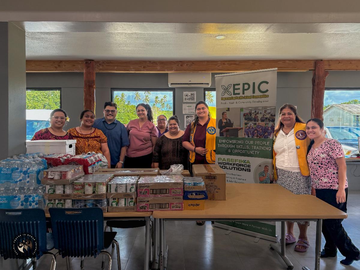 Group photo of Lions Club and OSS members with their food donations, canned food and water.