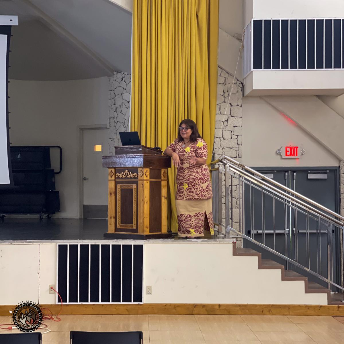 State Director Tafa presenting at the podium