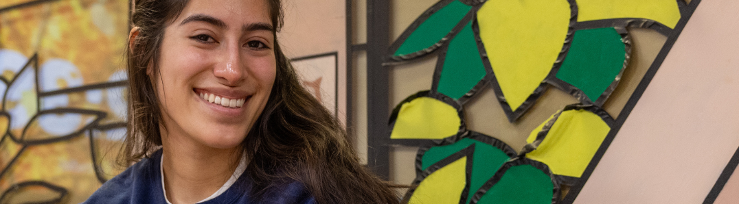 An image of a student in the Library smiling