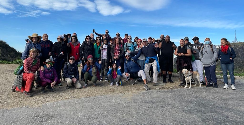 GROUP OF HFS HIKERS WITH THE HOLLYWOOD SIGN IN THE BACKGROUND