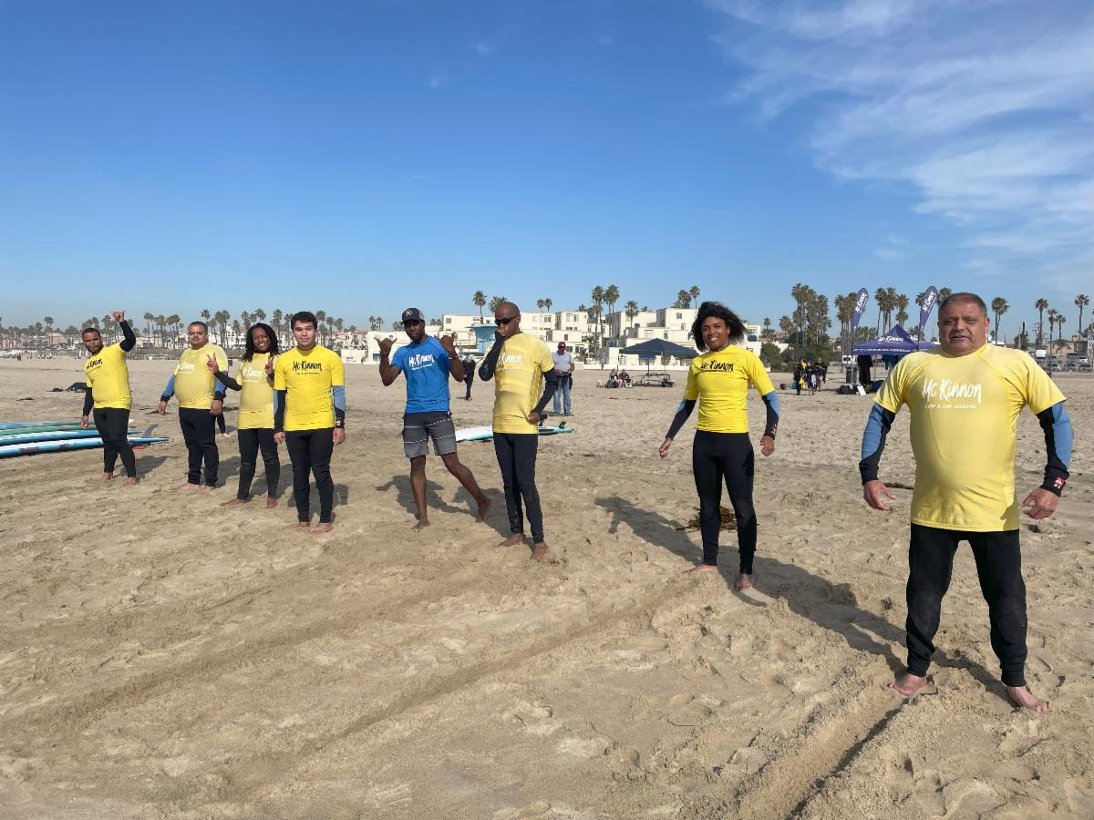 HFS Participants standing on beach preparing for surf lessons.