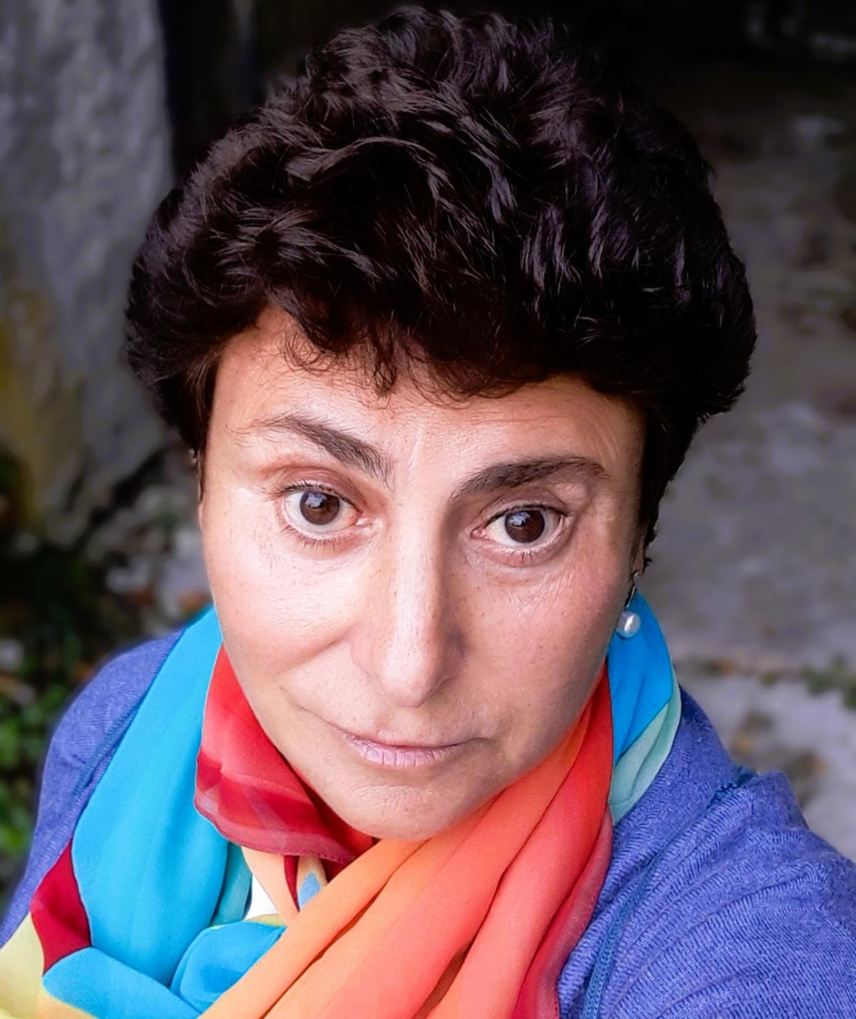 woman with colorful top and scarf looking forward