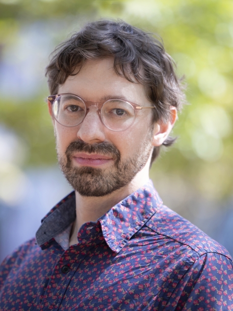 man wearing glasses looking ahead outdoors