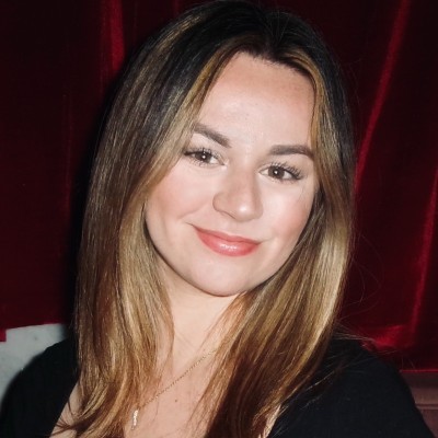 woman smiling in front of red backdrop