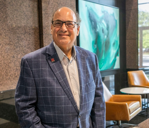 man in suit wearing glasses and smiling