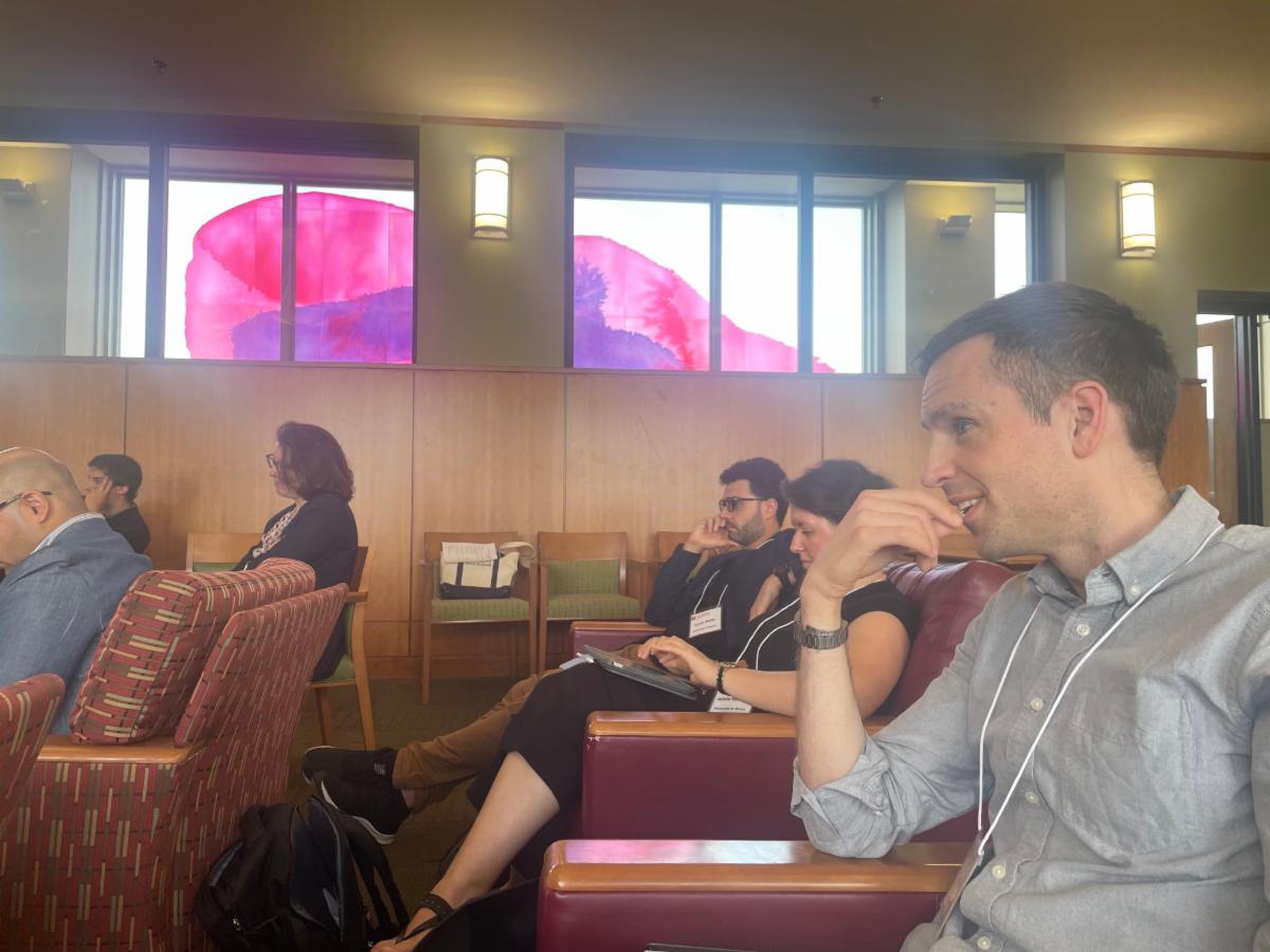 people seated looking forward with windows on the side of them