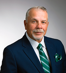 man in suit turned slight to right and grinning