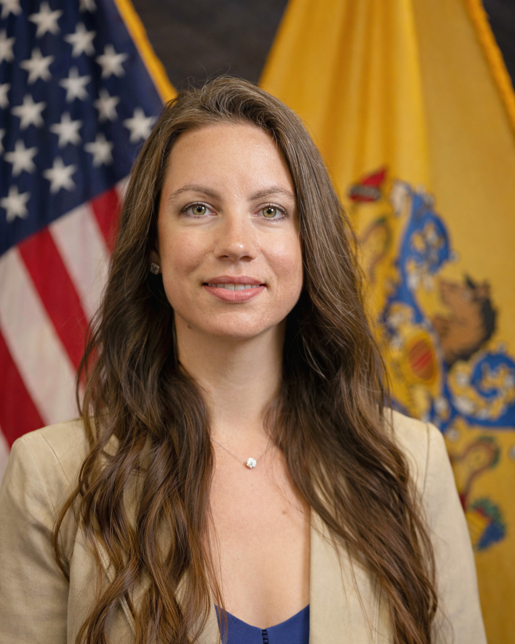 woman smiling with American flag and New Jersey flag behind her
