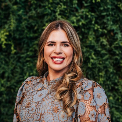 woman smiling in front of greenery wall