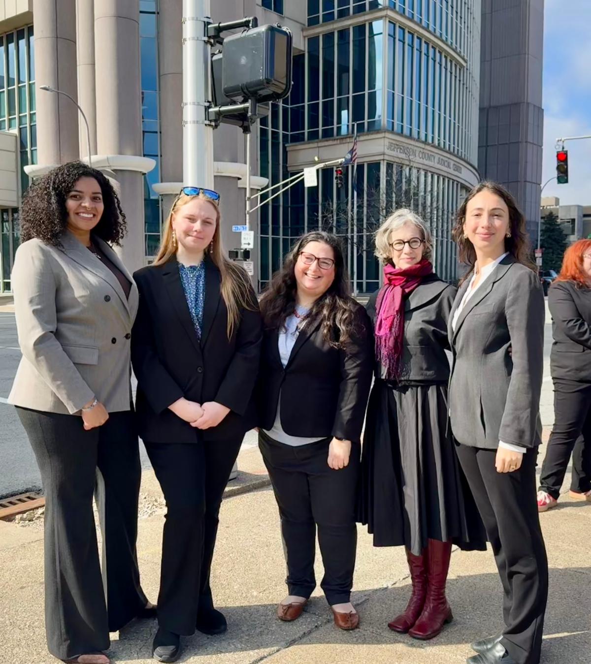 women standing together in front of courthouse