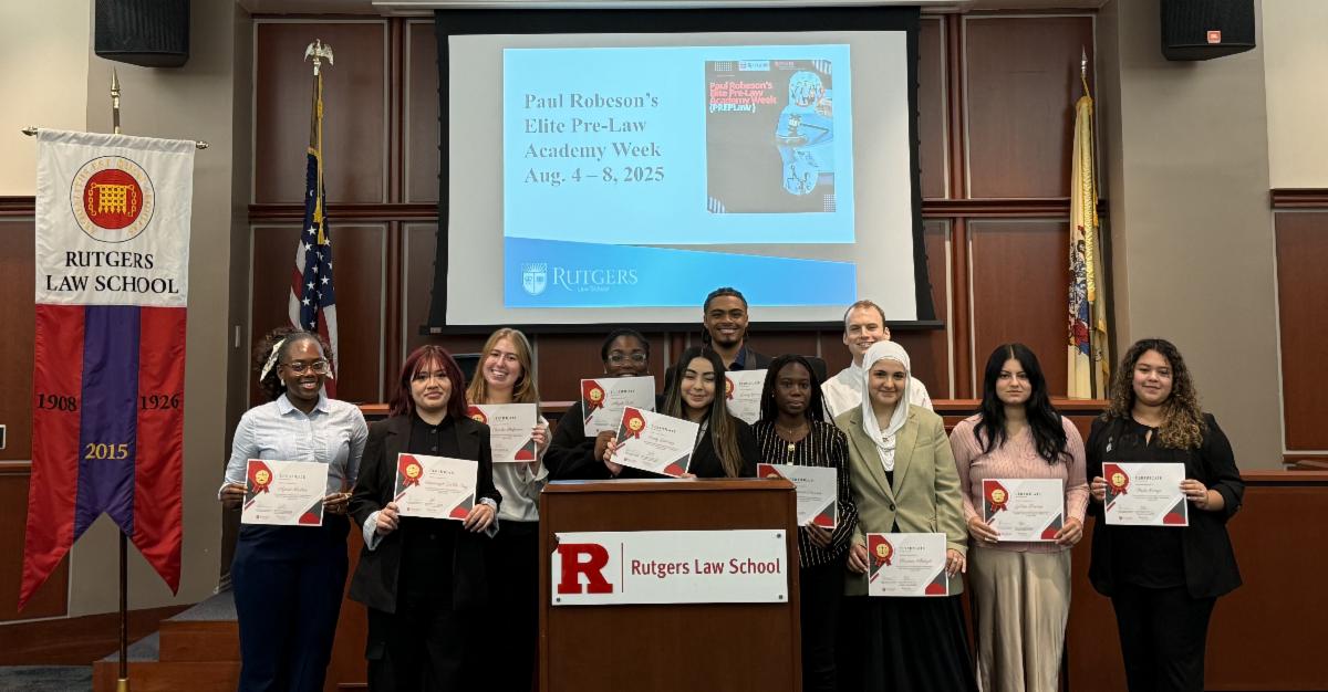 men and women holding certificates in mock courtroom