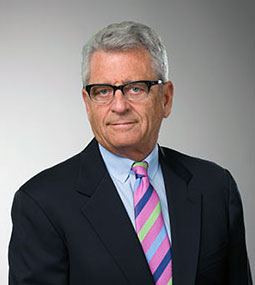 man grinning and wearing suit looking forward
