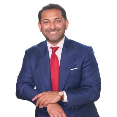 man in blue suit and red tie smiling