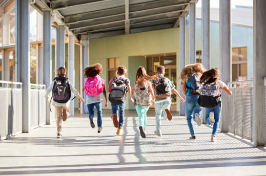 Kids running away from camera, leaving school for break