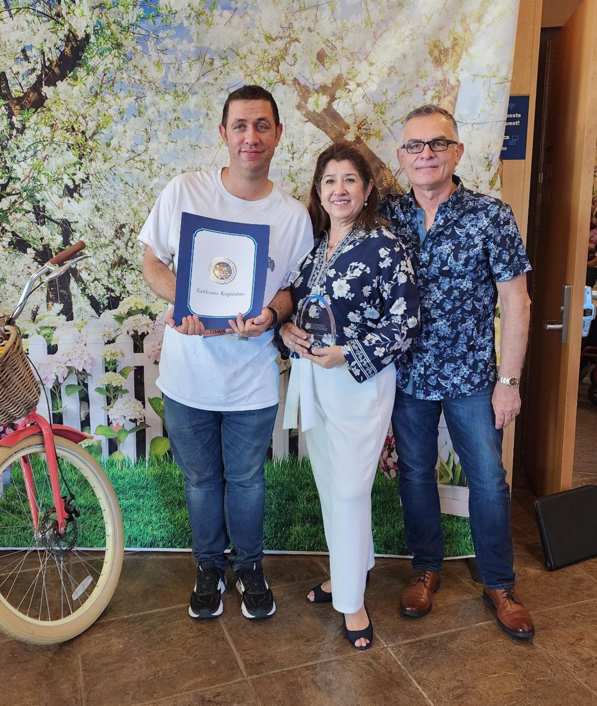 Image of SELPA staff with family holding a certificate next to a bicycle