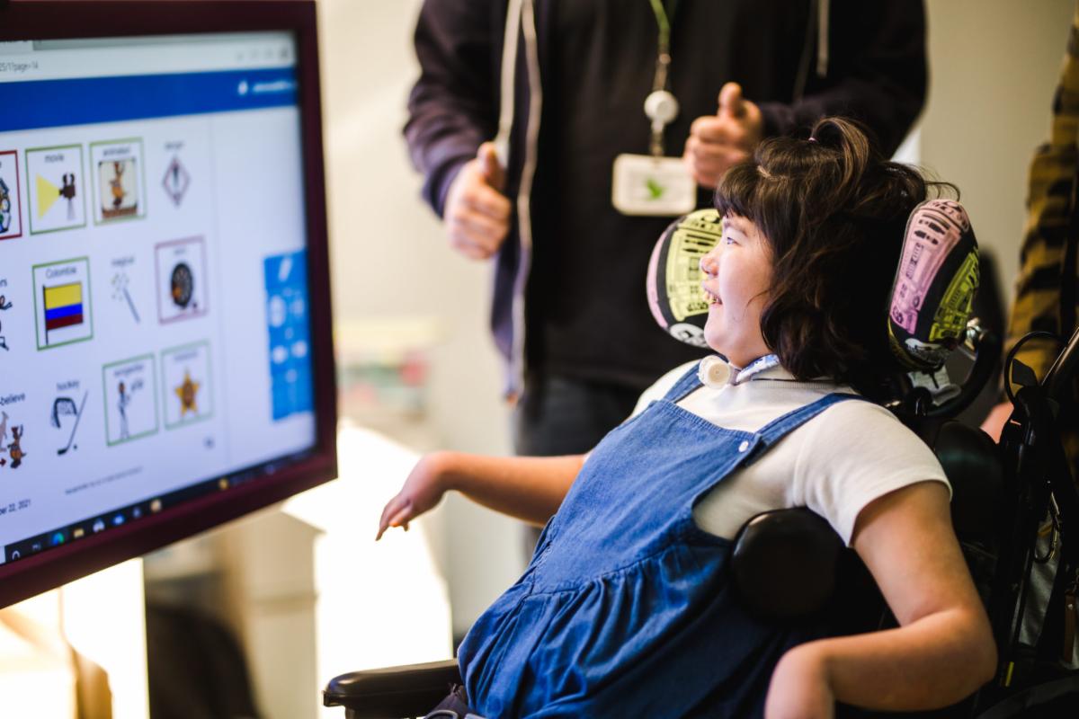 Student in wheelchair using SMART communication board in classroom