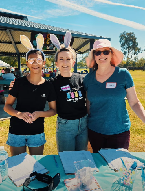 Three staff members and volunteers posing together with bunny ear headbands