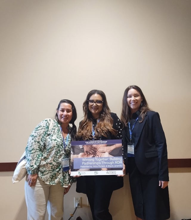 ADR Team members posing together, holding a sign with their presentation title.